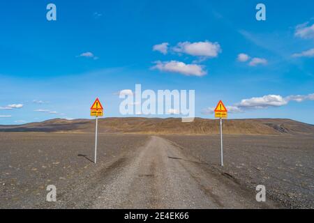 Due cartelli in piedi sulla ghiaia fuori strada che avverte circa entrare nelle Highlands abitabili senza strade asfaltate, e la necessità di utilizzare le automobili 4WD in islandese Foto Stock