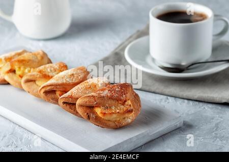 Biscotti fatti in casa con formaggio casereccio e una tazza di caffè su sfondo grigio. Cottura fatta in casa Foto Stock