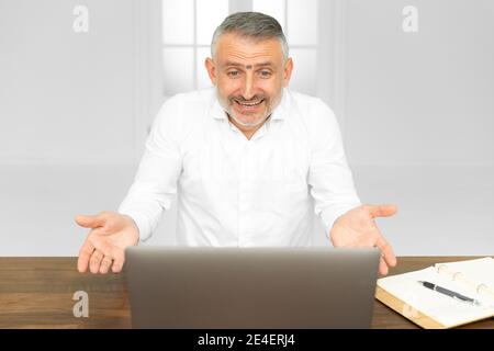 Confuso giovane uomo frustrato da problemi online guardando lo schermo del portatile, lavoratore tormentato facendo duro lavoro sul computer facendo note, studente si sente stres Foto Stock