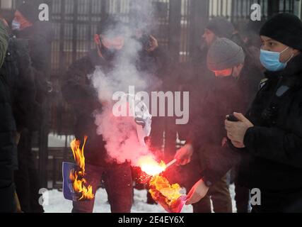 I manifestanti di estrema destra bruciano i cartelli durante la dimostrazione. I sostenitori russi del leader dell'opposizione Alexei Navalny manifestano al di fuori dell'ambasciata di Russia chiedendo il suo rilascio dopo la detenzione al suo ritorno in Russia dalla Germania, dove si stava riprendendo dall'avvelenamento da agenti nervosi, riferito dai media. Foto Stock