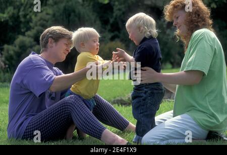 due madri che giocano con i loro bambini della sindrome di down Foto Stock