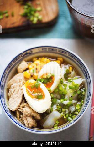 Zuppa giapponese di noodle ramen con pollo, mais, capesante, tagliatelle di riso Foto Stock