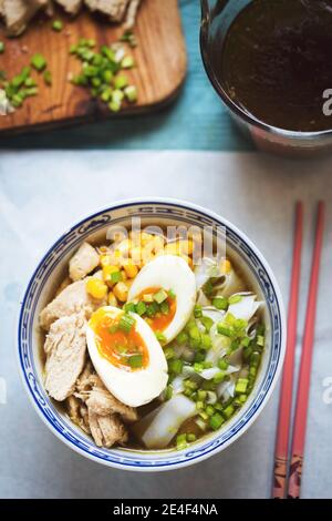 Zuppa giapponese di noodle ramen con pollo, mais, capesante, tagliatelle di riso Foto Stock