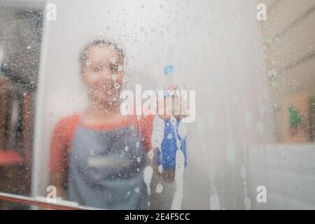 durante la pulizia, qualcuno ha spruzzato il vetro con uno spruzzatore di bottiglie il bagno Foto Stock