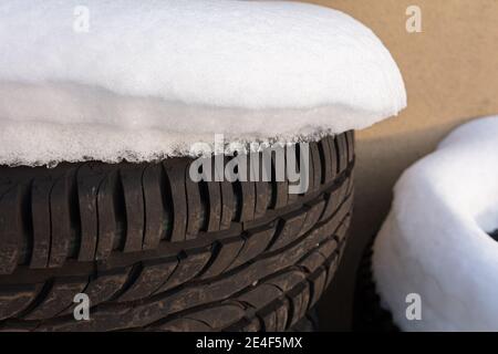 Vecchi pneumatici sotto la neve bianca. Foto di alta qualità Foto Stock