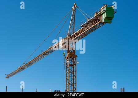 Paesaggio industriale con sagome di gru sullo sfondo del tramonto Foto Stock