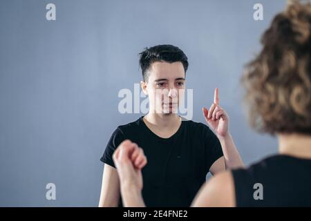 L'istruttore di taekwondo femminile conduce una sessione di allenamento personale per la giovane donna in palestra. Ragazza che padroneggia il nuovo taekwondo si muove durante la classe con allenatore. Exe Foto Stock