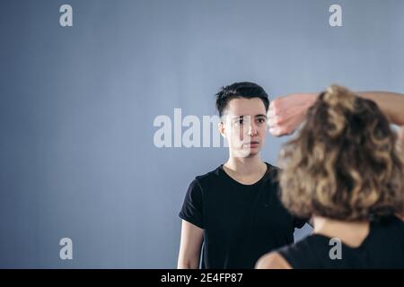 Allenatore insegna all'atleta a colpire il calcio. Forti atleti di arti marziali femminili nella loro formazione taekwon-do. Due giovani donne istruttore e studente che pratica Foto Stock