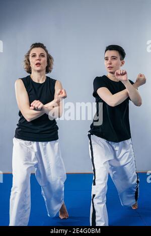 Due combattenti femminili di arti marziali praticano in palestra. Taekwondo allenatore e studente in formazione personale. Classe di autodifesa per le donne. Addestramento dei combattenti Foto Stock