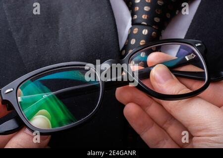 Primo piano di un uomo d'affari in tuta e cravatta di tenuta occhiali Foto Stock