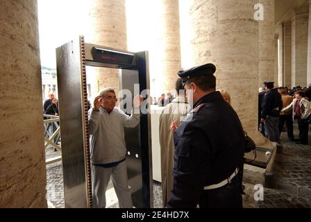 I fedeli devono camminare attraverso un metal detector mentre entrano in Piazza San Pietro, in Vaticano, a Roma, il 10 aprile 2004. Il Vaticano dice che rivedrà le sue procedure di sicurezza dopo che una donna ha saltato una barriera nella Basilica di San Pietro durante la Messa della vigilia di Natale e ha abbattuto il papa. il papa è protetto da una combinazione di guardie svizzere, polizia Vaticana e polizia italiana. Foto di Eric Vandeville/ABACAPRESS.COM Foto Stock