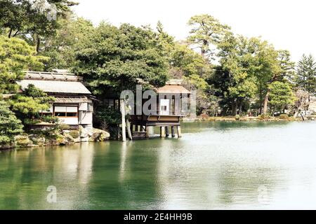 Tranquillo scenario di un tradizionale edificio giapponese in un lago nel parco Kenroku-en Garden, Kanazawa, Giappone Foto Stock