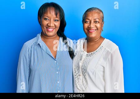 Famiglia ispanica di madre e figlia che abbracciano insieme con amore aspetto positivo e felice in piedi e sorridente con un fiducioso sorridi mostrando i denti Foto Stock