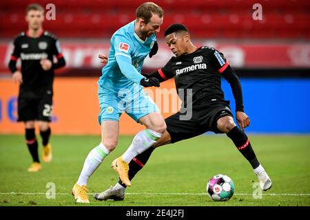 Leverkusen. 24 gennaio 2021. Maximilian Arnold (L) di Wolfsburg vies con Leon Bailey di Leverkusen durante una partita di calcio della Bundesliga tedesca tra Bayer Leverkusen e VfL Wolfsburg a Leverksuen, Germania, 23 gennaio 2021. Credit: Xinhua/Alamy Live News Foto Stock