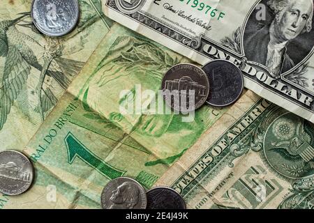 Un dollaro (USD) e un Real Notes (BRL) insieme con alcune monete Foto Stock