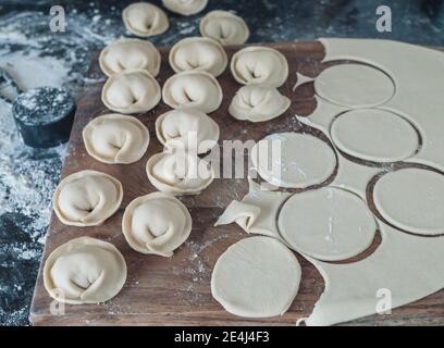 Pelmeni - gnocchi russi con impasto sul lato. Foto Stock