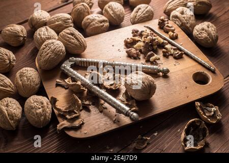 Una foto ravvicinata di noci intere nella loro conchiglia, conchiglie rotte e noci sgusciate. Foto Stock