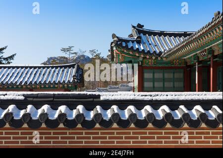 Scenario mattutino invernale coreano, tradizionale casa di hanok coperta di neve all'interno del Palazzo di Gyeongbokgung. Foto Stock