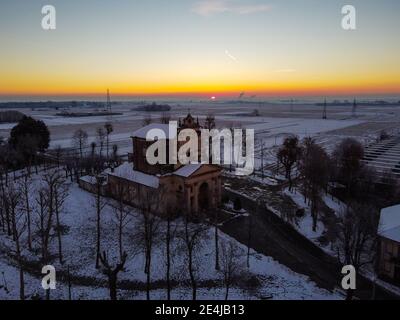 Sole che sorge sulla pianura innevata e il santuario di Varallino di Galliate, Novara, Piemonte, Italia Foto Stock