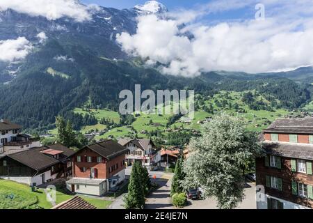 Vista di Grindelwald, nell'Oberland Bernese, Svizzera preso dal treno, che mostra la città e le montagne sullo sfondo Foto Stock