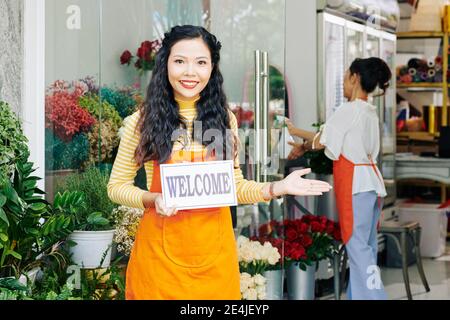 Fiorista con cartello di benvenuto Foto Stock