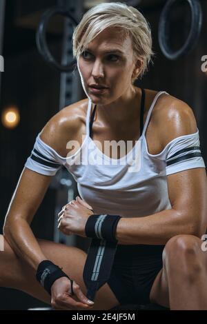 Ritratto di donna sportiva bionda con t-shirt bianca e fascia antisudore palestra Foto Stock