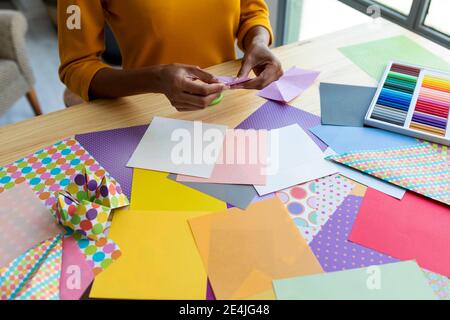 Artista Origami seduto in studio pieghevole carta colorata Foto Stock