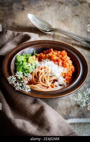 Piatto di spaghetti bolognesi vegetariani con fiori selvatici, scalogno e farro grunkern Foto Stock