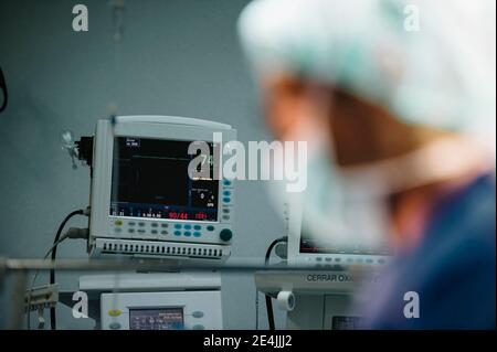 Chirurghi maschili visti dal vetro durante l'esecuzione di operazioni in ospedale Foto Stock