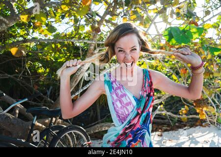 Percorso sportivo maturo che corre in montagna sul prato contro il cielo blu Foto Stock