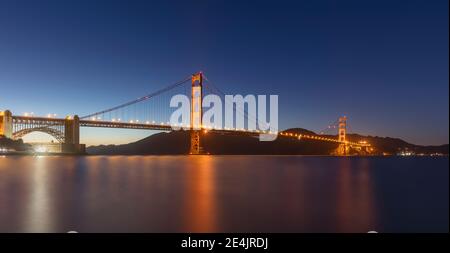 Ponte illuminato Golden Gate sul mare contro il cielo limpido a San Francisco, California, USA Foto Stock