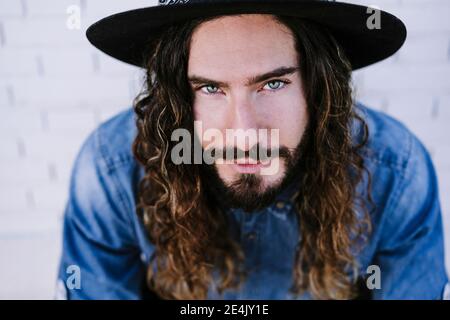 Giovane uomo alla moda con gli occhi grigi che indossano il cappello Foto Stock