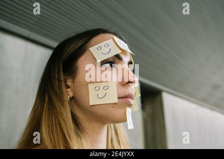 Ritratto di donna seria che indossa note adesive sul viso Foto Stock