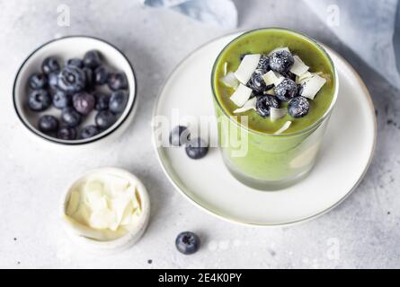 budino di chia con polvere di supercibo verde, condito con mirtilli, patatine di cocco Foto Stock