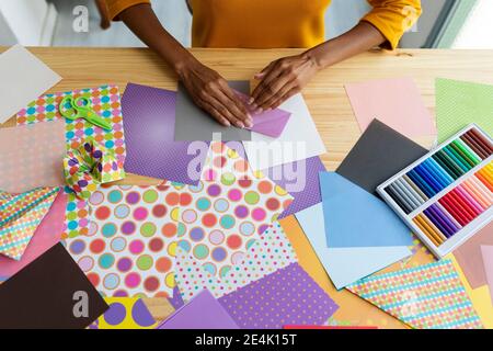 Artista Origami seduto in studio pieghevole carta colorata Foto Stock