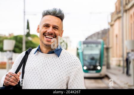 Sorridente commuter maschile alla stazione ferroviaria Foto Stock
