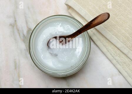 Olio di cocco con cucchiaio di legno Foto Stock