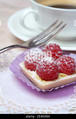 Pasticceria con lamponi e tazza di caffè Foto Stock