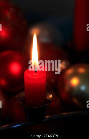 Rosso ardente candela di avvento e baubles di Natale Foto Stock