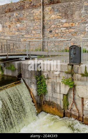 Eglinton Canal Lock con acqua che scorre formando piccole cascate, una recinzione metallica e muro di pietra, corsi d'acqua di Galway, ingegneria idroelettrica, Galway Foto Stock