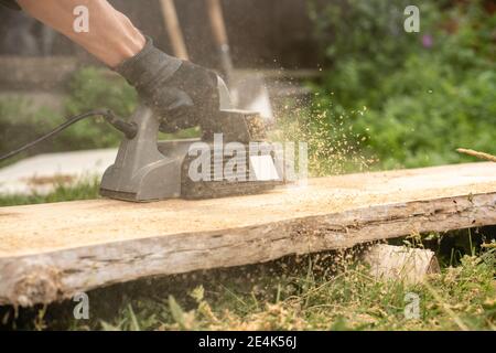 Mani di uomo che segano la tavola con sega circolare Foto Stock