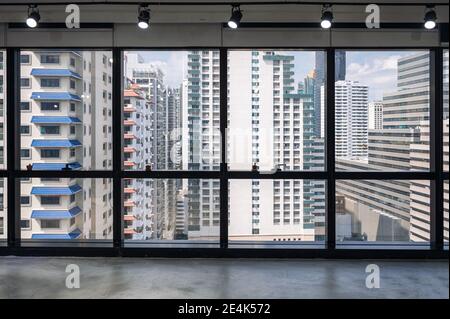Ufficio interno con finestra e affollato edificio in centro a. quartiere degli affari Foto Stock