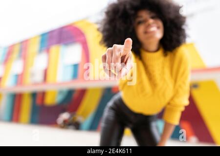 Donna che punta il dito mentre si sta in piedi all'aperto Foto Stock