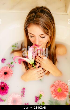 Giovane donna che prende il bagno del latte in bagno Foto Stock