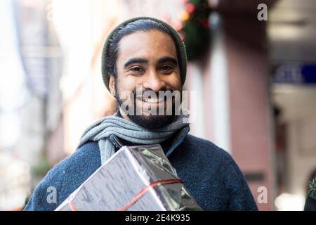 Primo piano ritratto di giovane bearded con regalo di Natale Foto Stock