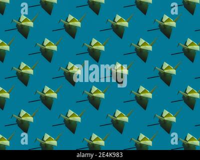 Origami di uccelli verdi su sfondo blu Foto Stock