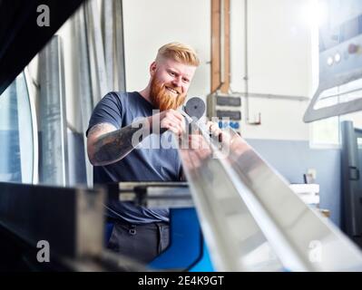 Addetto al controllo del materiale durante il lavoro in fabbrica Foto Stock