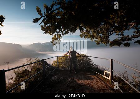 esploratore maschile con zaino ammirando la vista della valle del Danubio a Beuron, Alb Svevo, Germania Foto Stock