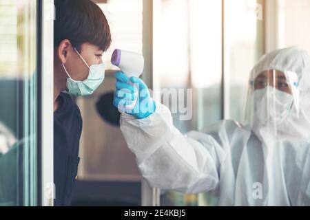 Medico che misura la temperatura con il nuovo termometro digitale per la paziente Durante la pandemia del virus della corona - Assistenza sanitaria e attrezzature mediche concetto Foto Stock