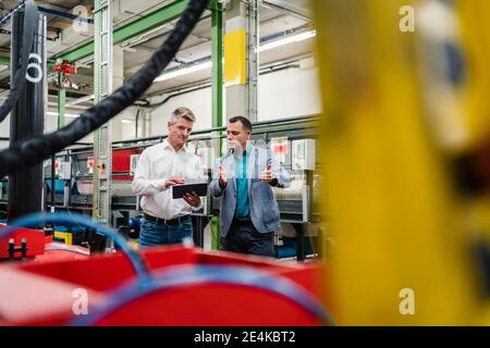 Ingegnere maschile e supervisore che lavorano insieme al tablet digitale fabbrica Foto Stock